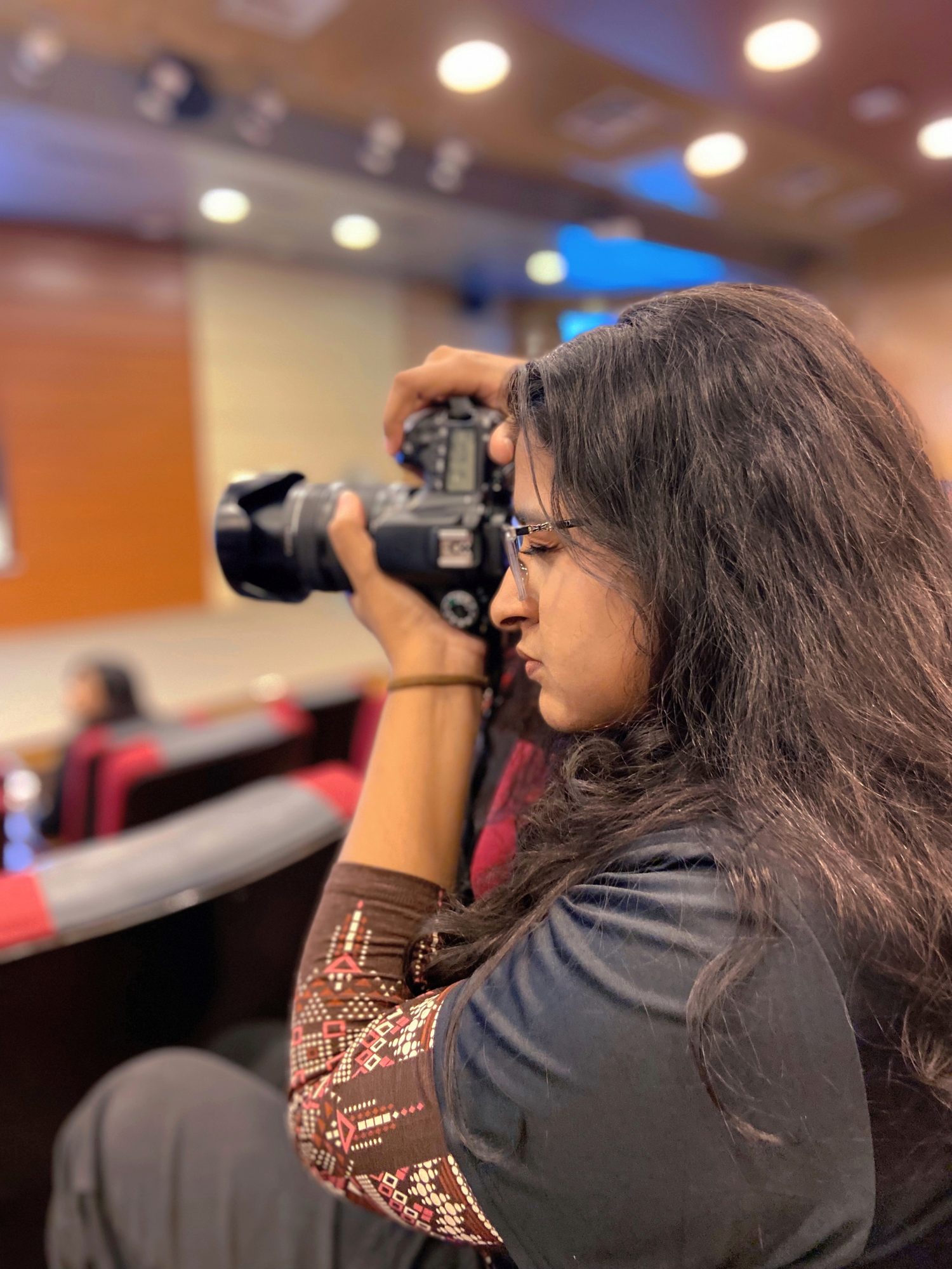 Nuzhat photographing an event with a DSLR camera